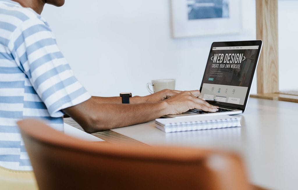 Man Designing Website on Laptop
